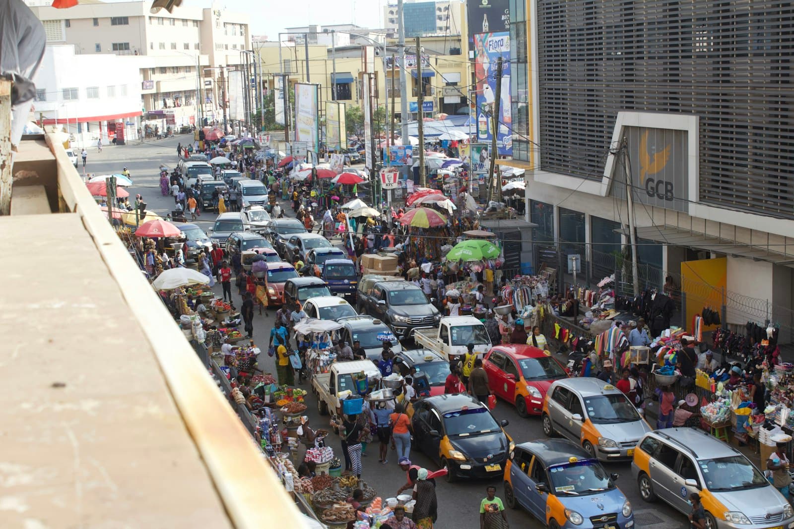 A busy Accra street with taxis, umbrellas and people selling